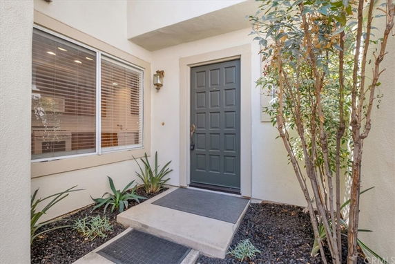 Front view of a house entrance with a dark door and large window.