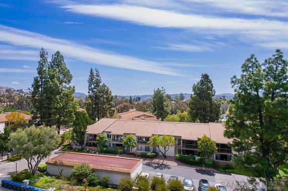 Aerial view of a residential area with single-story houses and surrounding trees.