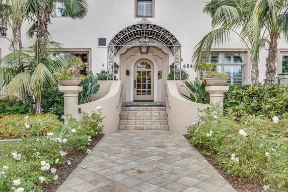 Front view of a house with decorative entrance and lush landscaping.