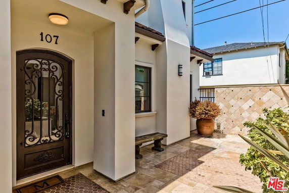Front view of a house with a decorative entrance and tiled flooring.