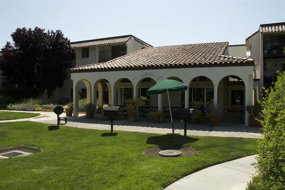 Front view of a single-story building with arched entrances and a tiled roof.