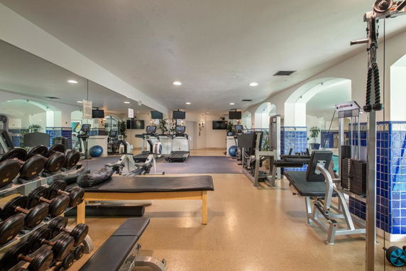Interior view of a gym with exercise equipment and weights.