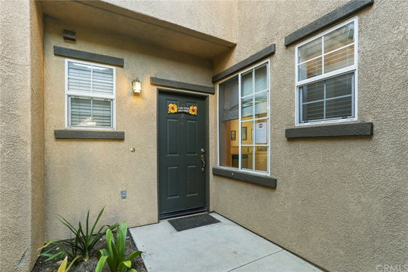 Front view of a house entrance with a dark door and multiple windows.