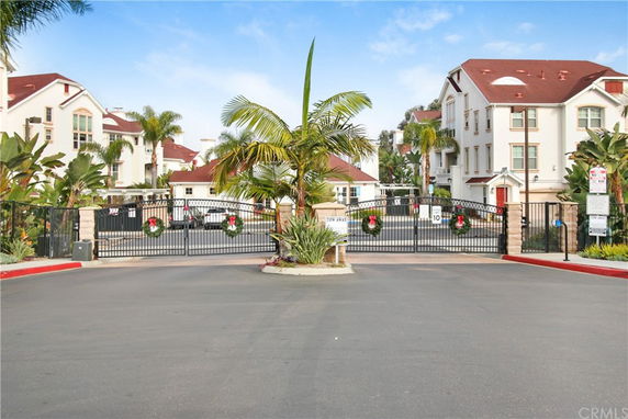 Front view of a residential complex with multiple multi-story buildings and a gated entrance.