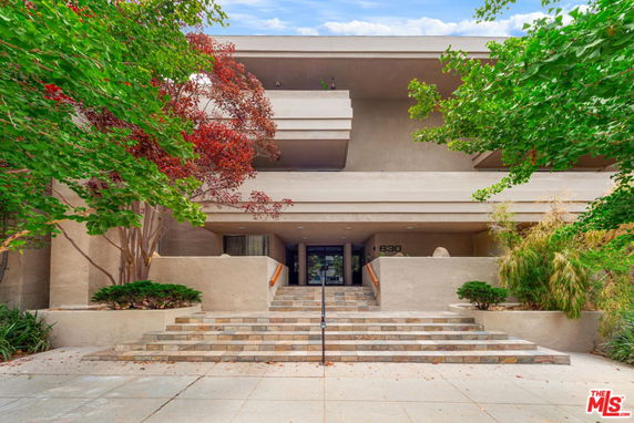 Front view of a building entrance with stairs leading up to the main doors.