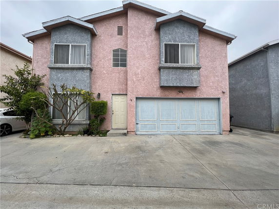 Front view of a two-story house with a double garage and pink exterior.