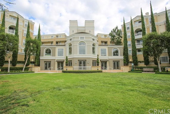 Front view of a multi-story residential building with large windows and ornate architectural features.