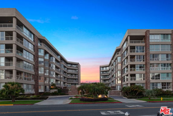Front view of two modern multi-story buildings with balconies.