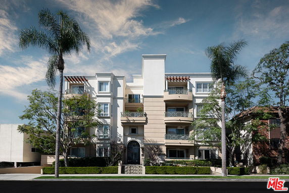 Front view of a multi-story residential building with balconies.