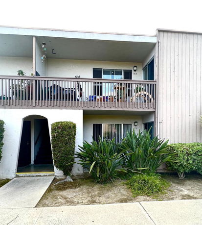Front view of a two-story apartment building with covered balconies and entrance.