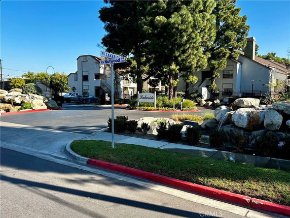 Front view of a residential building with a gated entrance and signpost.