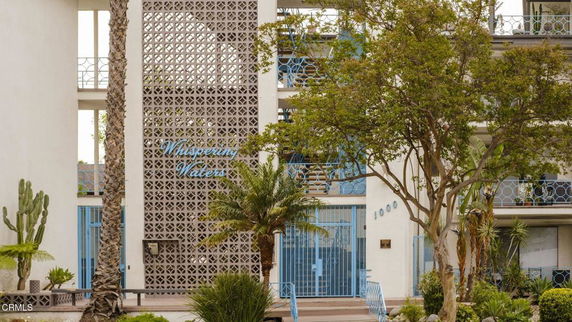 Front view of a multi-story building with decorative grille and balconies.