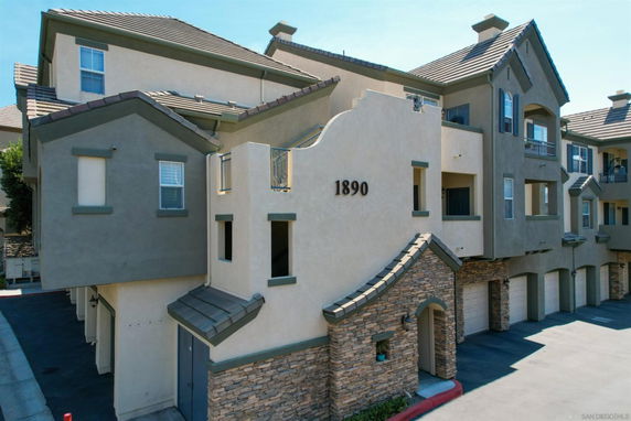 Front view of a multi-story residential building with garages on the ground floor.