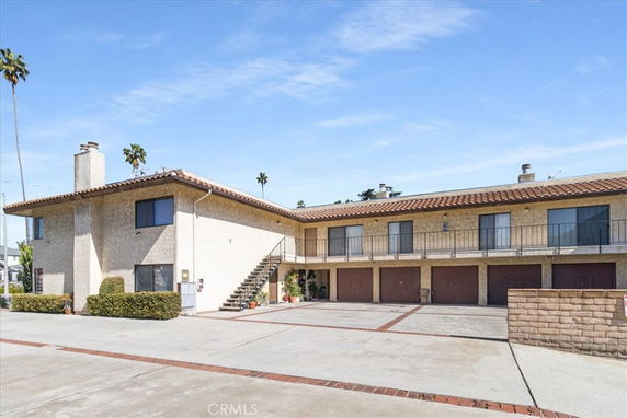 Front view of a two-story building with garages and a staircase.