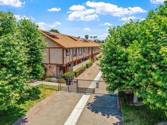 Front view of a row of connected townhouses with gated entrance.