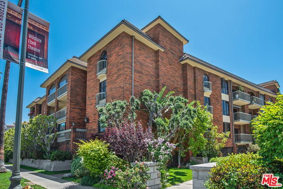Front view of a multi-story brick building with balconies.