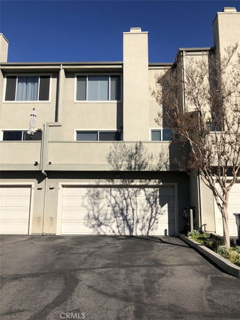 Front view of a multi-story residential building with attached garages.