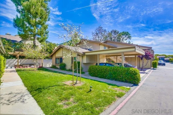 Front view of a house with a covered carport and landscaped front yard.