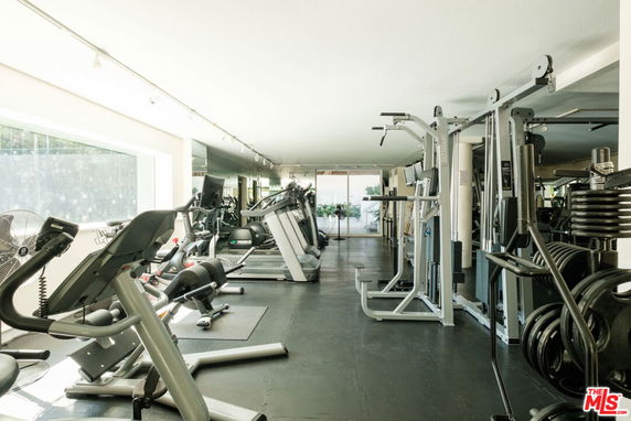 Indoor gym area with various fitness equipment and machines.