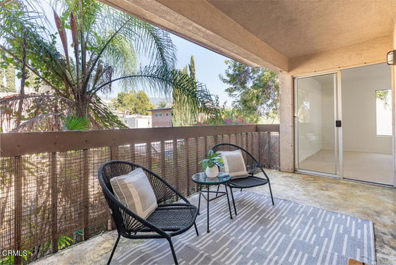View from a balcony with two chairs and a table.