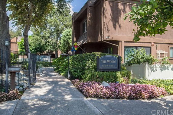Front view of a two-story apartment building labeled 'The Woods'.