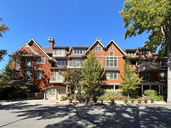 Front view of a multi-story residential building with gable roofs and balconies.