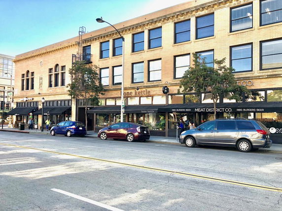 Front view of a three-story commercial building with shops on the ground floor.