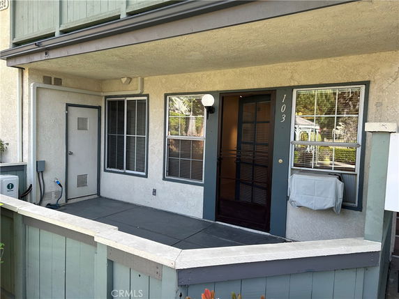 Front view of a building entrance with a covered porch and door marked 103.
