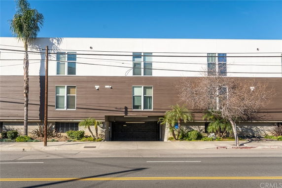 Front view of a modern multi-story building with a combination of white and brown facade.