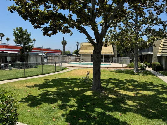 Outdoor swimming pool area surrounded by trees and fencing.