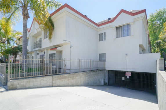 Front view of a multi-story building with a gated entrance and underground parking.