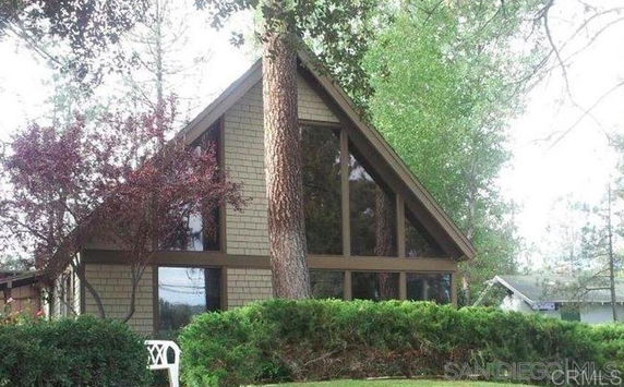 Front view of a triangular-shaped house with large windows.