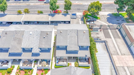 Aerial view of a residential complex with multiple rooftops and parking areas.