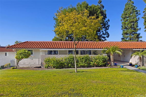 Front view of a single-story house with a red-tiled roof and attached garage.
