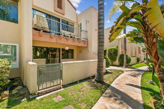 Front view of a two-story apartment building with balcony and patio.