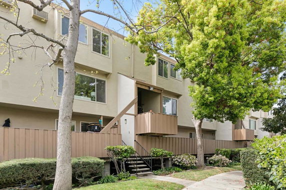 Front view of a multi-story residential building with balconies and large windows.