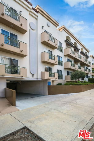Front view of a multi-story residential building with balconies.