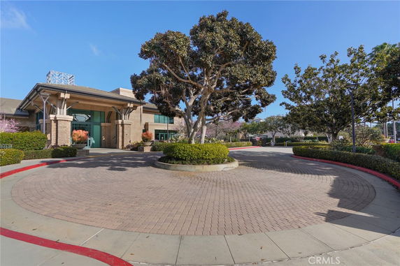 Front view of a building with a circular driveway and landscaped surroundings.