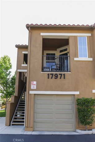 Front view of a two-story house with garage and balcony.