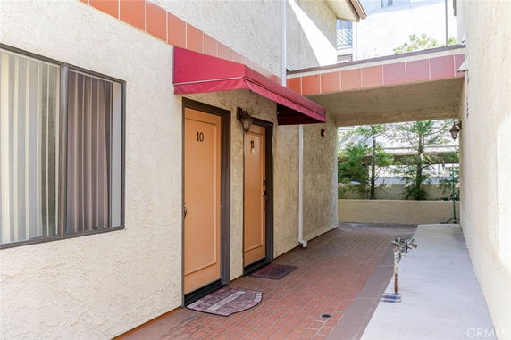 Outdoor view of building entrance with two doors and an awning.