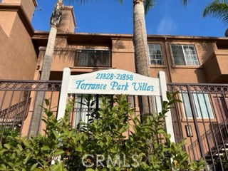 Front view of a multi-story building with a gated entrance marked 'Torrance Park Villas.'