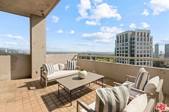 Terrace with outdoor seating offering a view of city buildings in the distance.