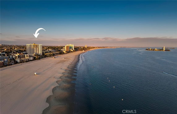 Wide-angle view of a beachside cityscape with multiple buildings and the ocean.