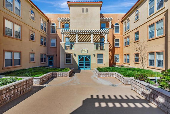 Front view of a multi-story residential building with a central entrance and balconies.