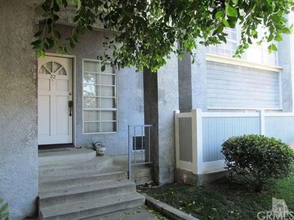 Front view of a house with a small porch and white front door.