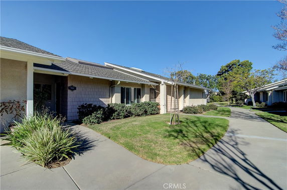 Front view of a single-story house with a walkway and landscaping.