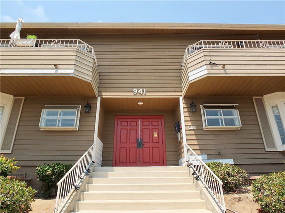 Front view of a multi-story building with retaining walls and balconies.