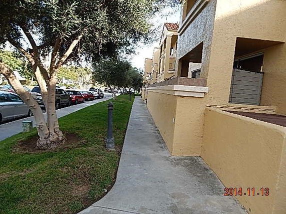 Sidewalk alongside a multi-story residential building with a beige exterior.