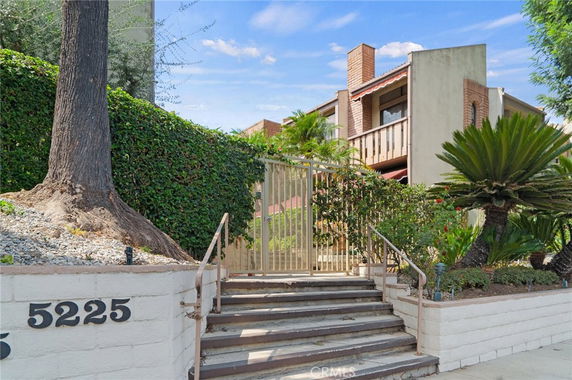 Front view of a multi-story building with a gated entrance.