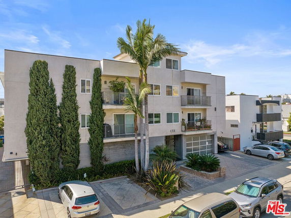 Front view of a multi-story apartment building with balconies.